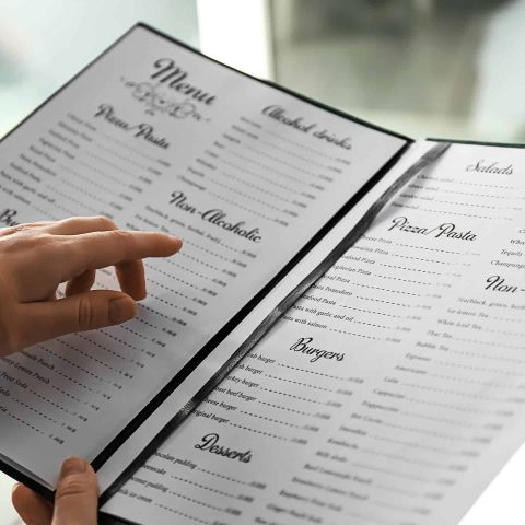 Woman reading menu in cafe, closeup